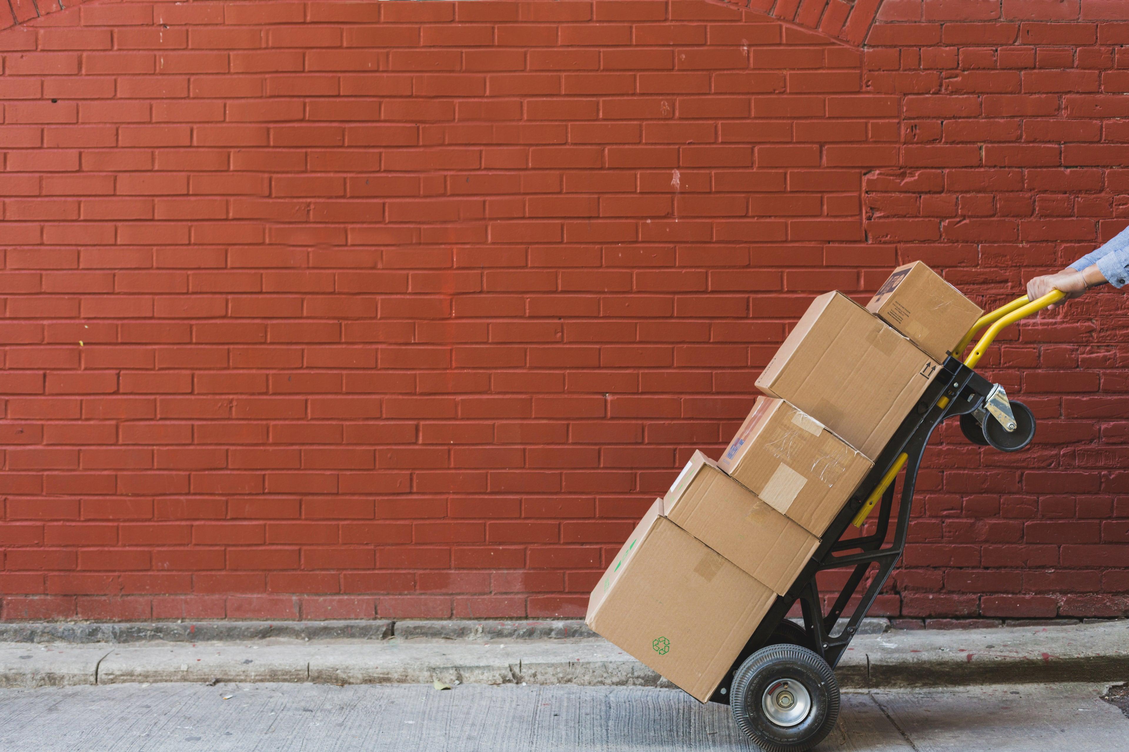 Shipping boxes stacked in front of a brick wall